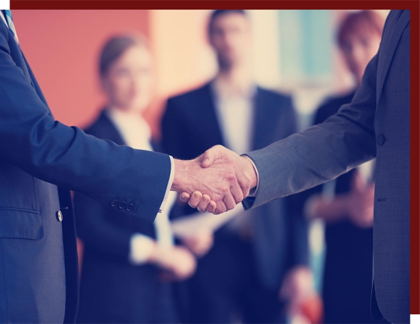 Handshake between Attorney and client with officer workers standing behind them.
